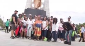 volunteer group in ghana from the united states taking a picture in front of a statue.